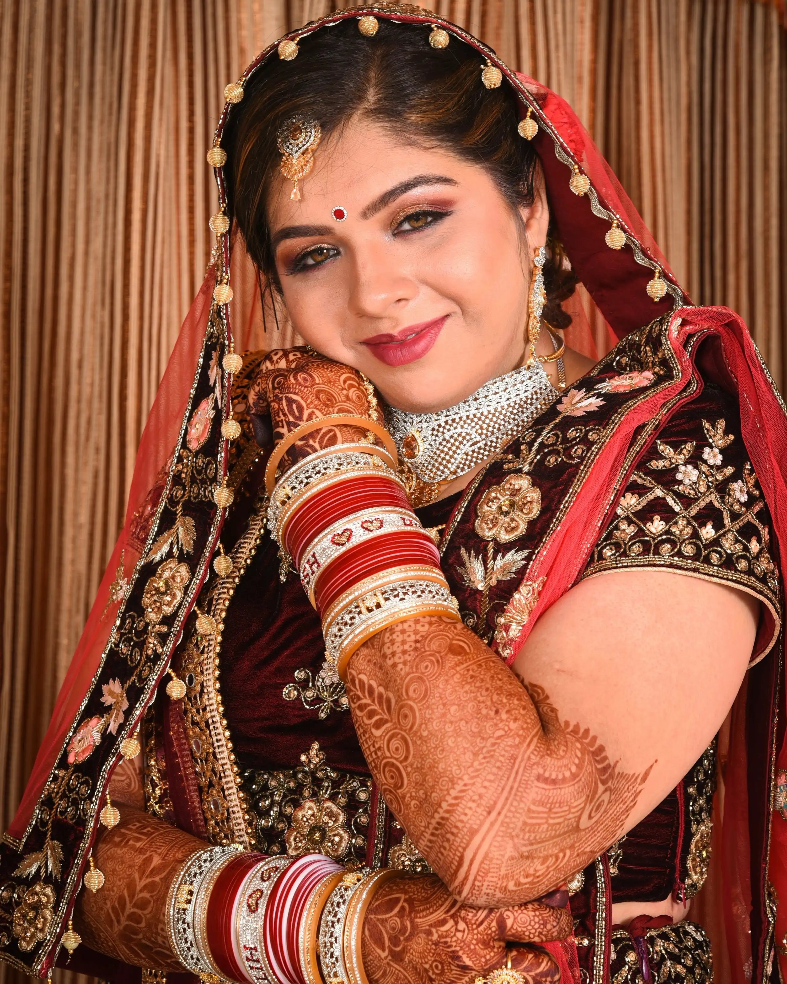 Bride in traditional red and gold bridal wear, makeup by Anita Raheja at Shadows Beauty Parlour, Khar West, Mumbai